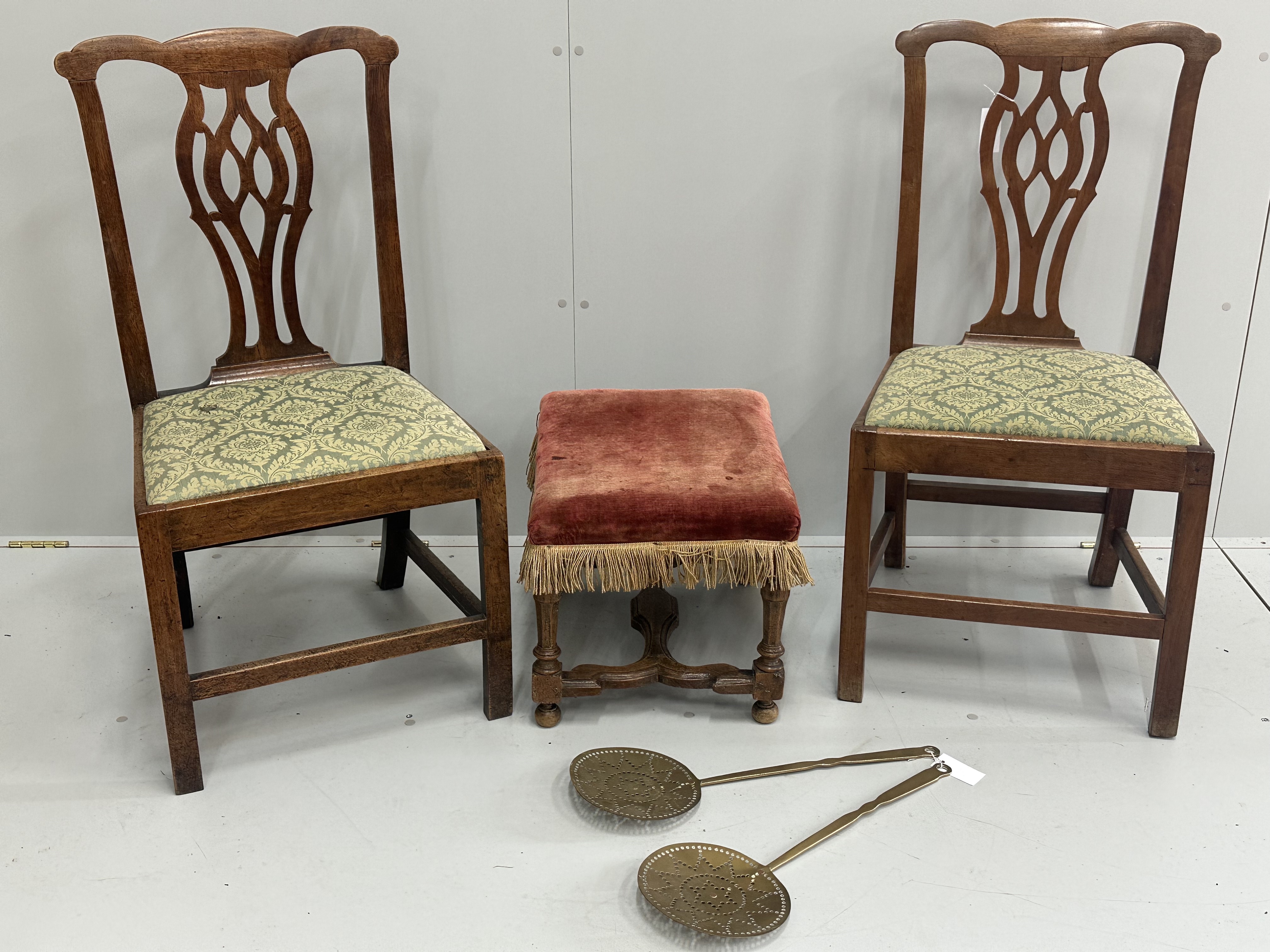 A pair of Chippendale style walnut dining chairs with drop in seats, an 18th century style walnut footstool and a pair of Victorian brass chestnut roasters